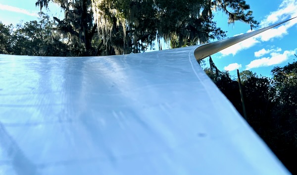 detail of shade sail curving around and into trees
