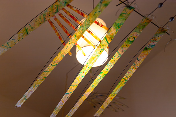 Close-up of a hand mobile element near a lamp at a residence