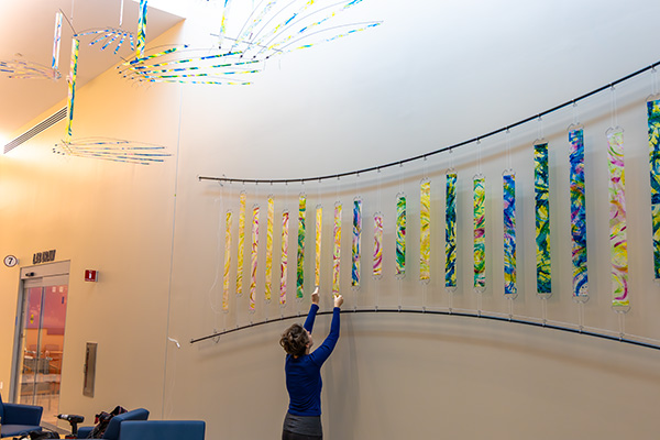 Ruth Whiting adjusting wall strips during the HandFlow installation at UF Health Shands