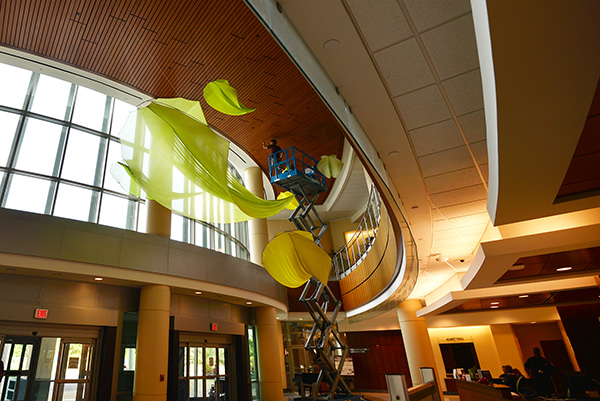 Tim Elverston installing the Flowx Greens kinetic piece at UF Health Shands Cancer Hospital